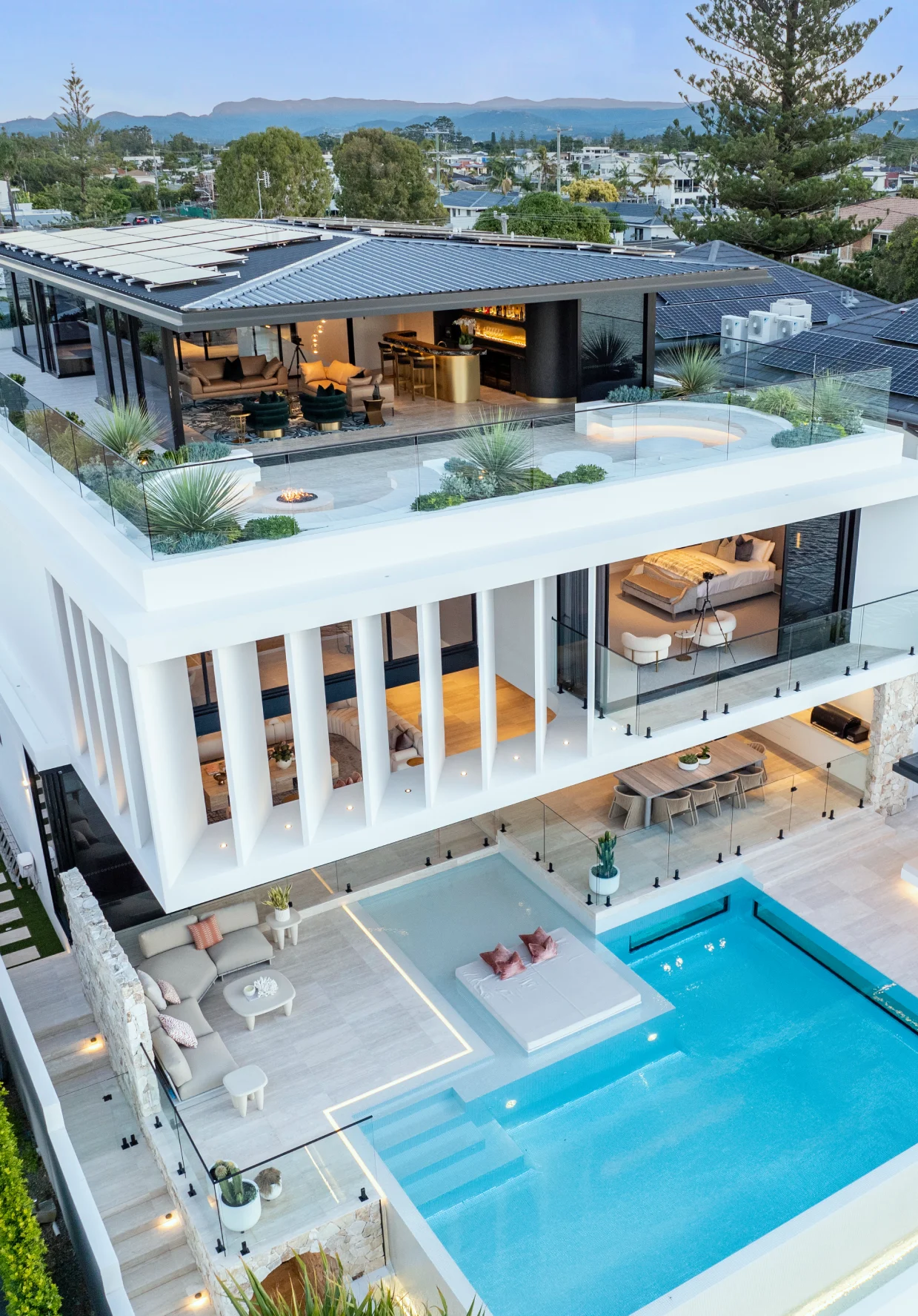 Aerial view of a multi-level luxury Broadbeach residence, featuring custom microcement applications across the rooftop terrace and exterior facades by Dune Artisan Finishes Co.